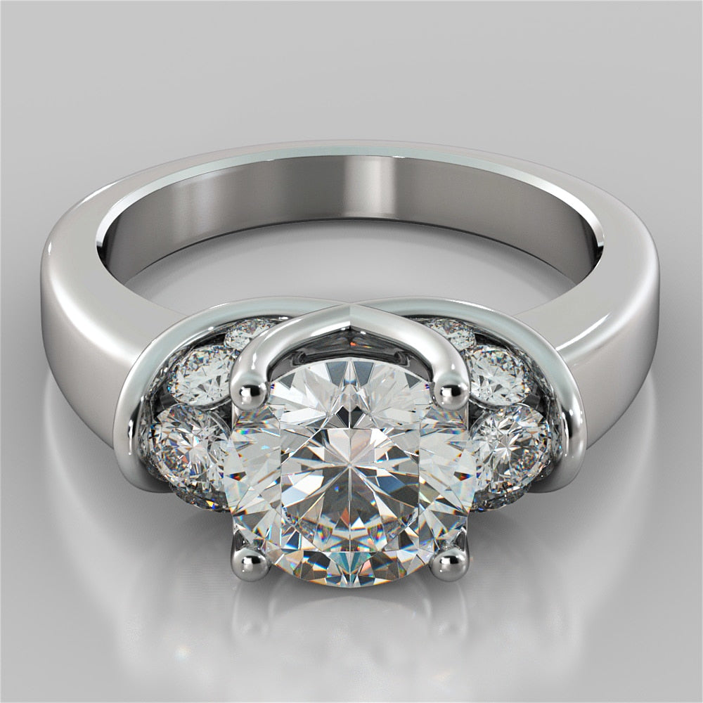 Silver ring with a central diamond and smaller diamonds on a gray background